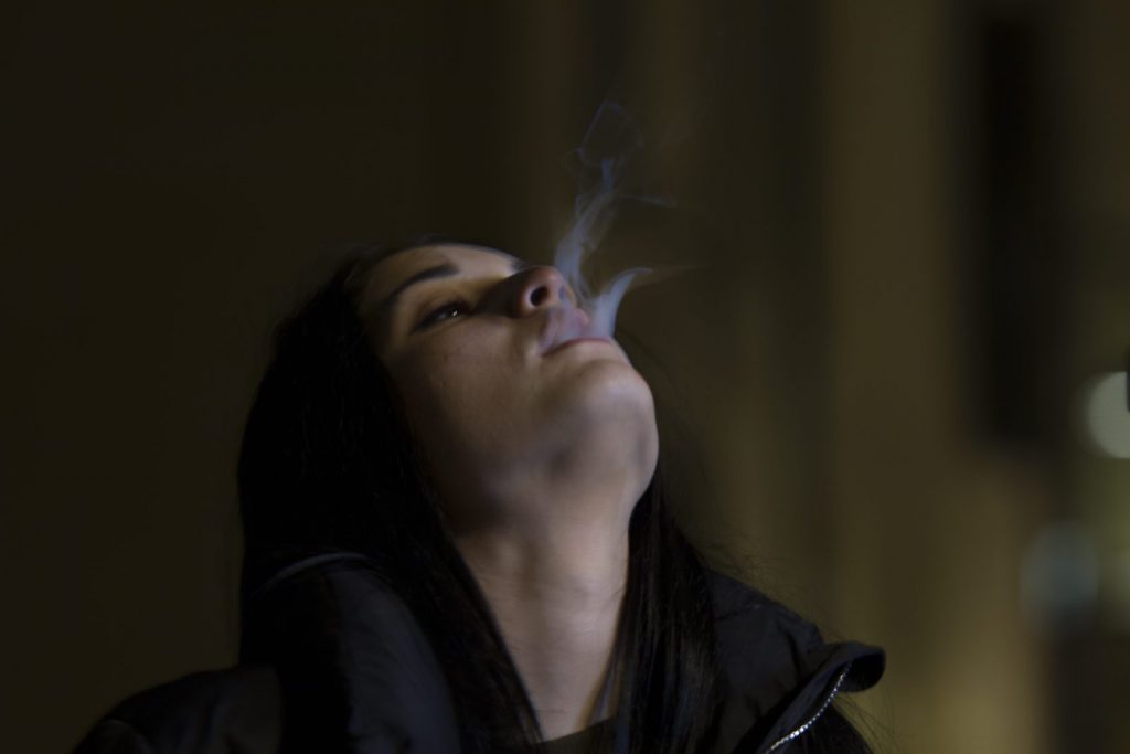 Woman with smoke outside her mouth